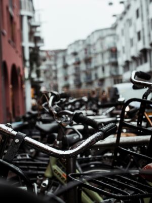 Close-up of parked bicycles in a city with modern buildings and urban design.